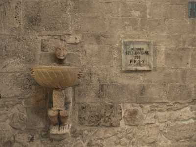 Sul muro esterno balza all'occhio un'acquasantiera singolare, con un "moro" che sorregge un bacile